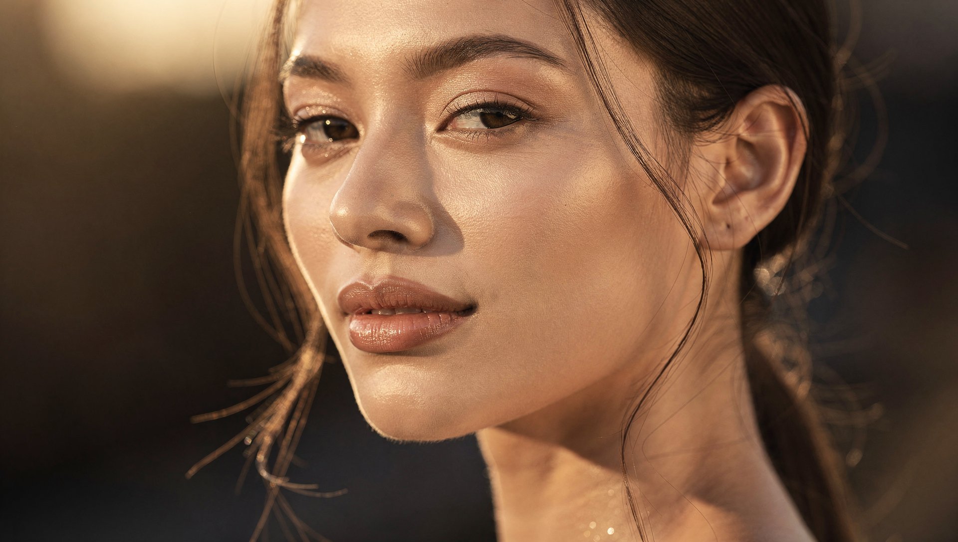 Jeune femme au visage lumineux dans une lumière dorée du matin, symbole d'un glow up et d'une transformation personnelle